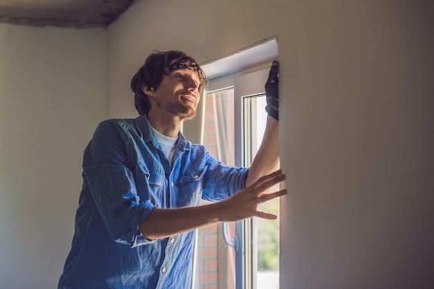 Man in a blue shirt does window installation