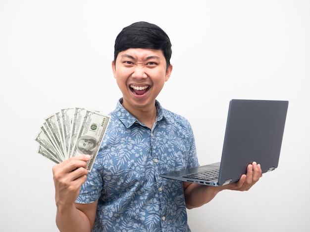 Мужчина в синей рубашке получает много денег, работая в Интернете, чувствует себя удовлетворенным и счастливым, показывая деньги