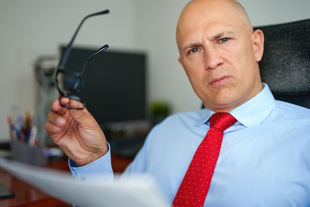 Man in blue shirt and red tie at office