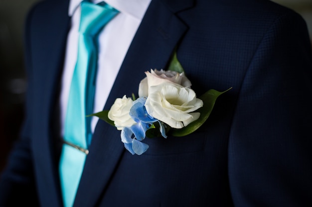 Man in blue suit tying the necktie