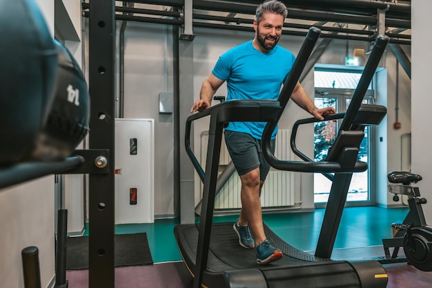 トレッドミルで運動する青い t シャツの男