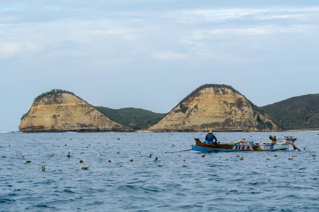 Man on boat in sea against sky