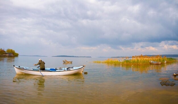 Foto un uomo in barca con un uomo in una barca nell'acqua