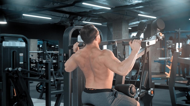 A man bodybuilder doing strength exercises in the gym