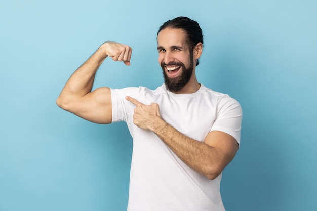 Man bodybuilder pointing finger at his arm biceps proud and satisfied with muscular build