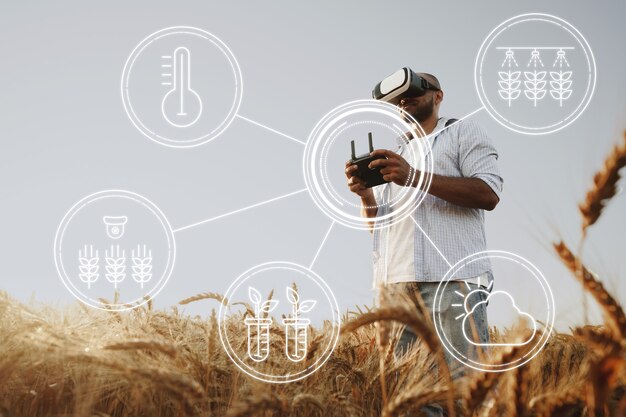 Man boer die in een tarweveld staat en de drone van dichtbij bestuurt. technologieën in landbouwconcept