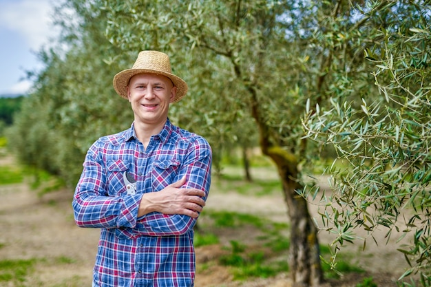 Man boer met strooien hoed op olijf plantage.