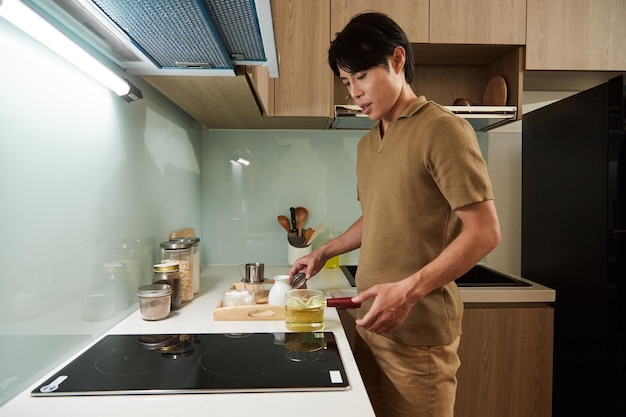 Man Boiling Water on Kitchen Stove