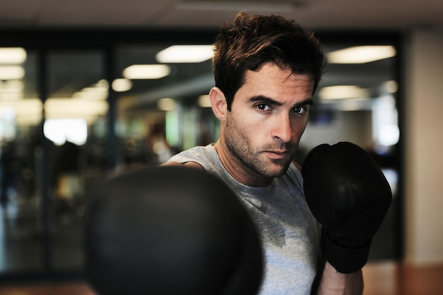 Foto man boksen handschoenen en punch met gym voor fitness wellness of training voor vechtprestaties of sport mma bokser of sterk voor wedstrijd wedstrijd of oefening voor ontwikkeling zweet en workout