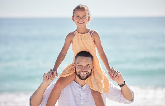 Man bonding en meisje in leuk strandspel op de schouders van de ouders door de oceaan of de zee van Spanje op zomervakantie met het gezin Portretglimlach en gelukkige vader met dochter spelen kind of kind in de natuuromgeving