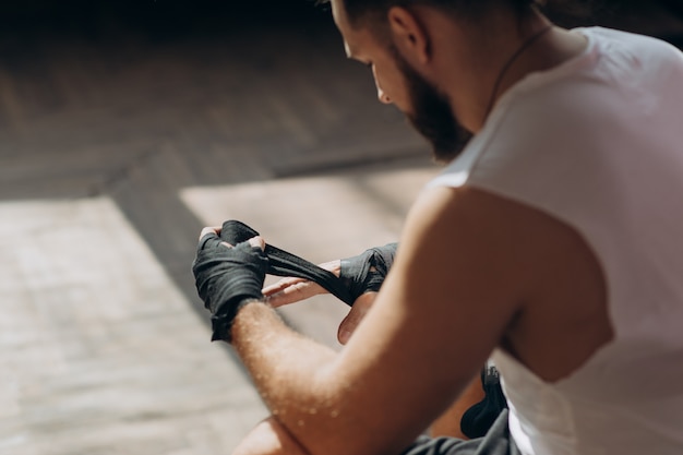 Man boxer wrapping hands prepararsi per una lotta. avvolgimento mani per guantoni da boxe