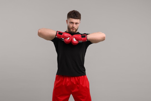 man in boxing gloves on grey background