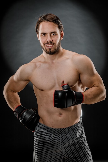 A man in Boxing gloves A man Boxing on a black background The concept of a healthy lifestyle