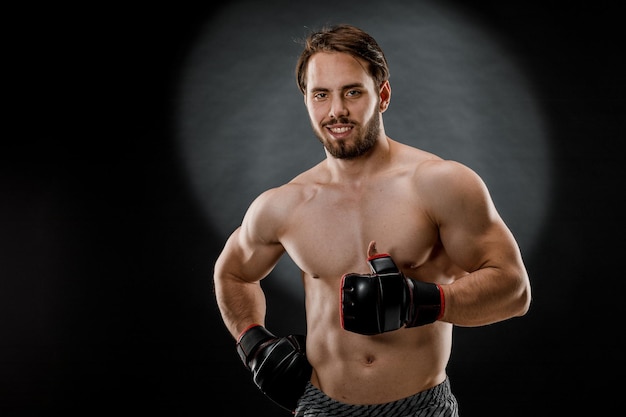 Мужчина в боксерских перчатках Мужчина боксирует на черном фоне Концепция здорового образа жизни