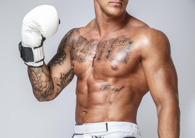 Man in boxing gloves posing in studio. Isolated on grey