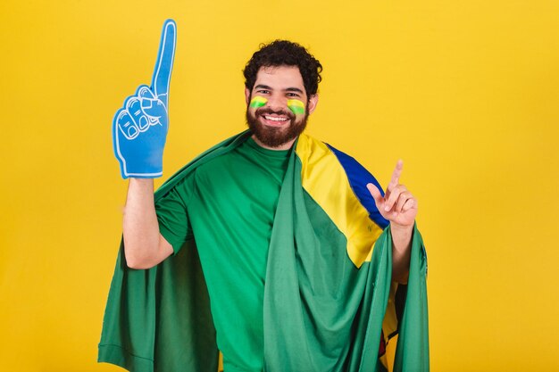 Man brazilian bearded soccer fan from brazil using foam\
finger