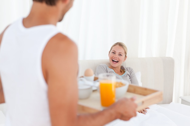 Man brengt het ontbijt naar zijn vrouw