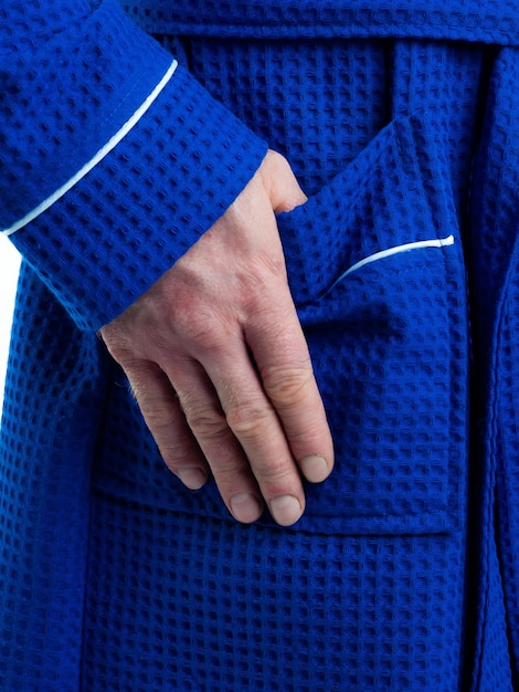 Man in a bright bath robe advertises clothing details on an isolated white background