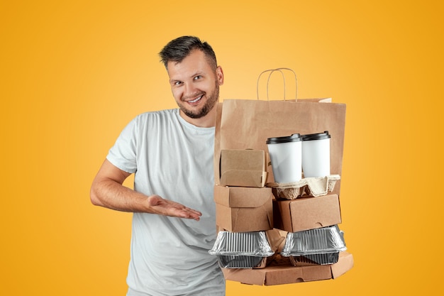 Man in a bright t-shirt giving a fast food order isolated on a yellow background