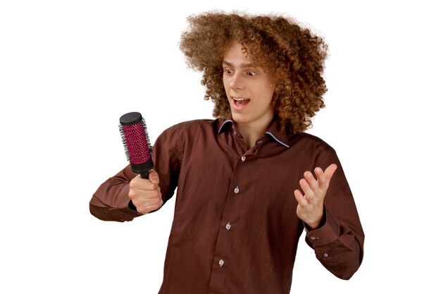 man in a brown shirt uses a metal round comb