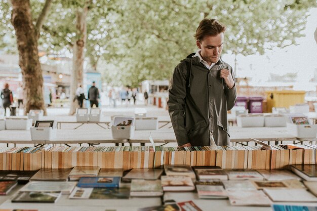 Мужчина просматривает подержанные книги в уличном книжном магазине