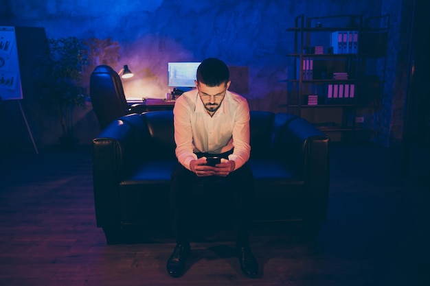 man browsing through his phone night office