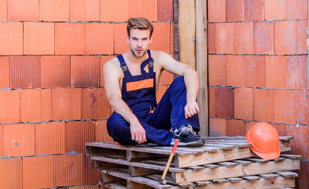 Man build own house Perform basic tasks Masculinity concept Break for relax Attractive worker Sexy laborer Building construction General maintenance repair worker Worker brick wall background
