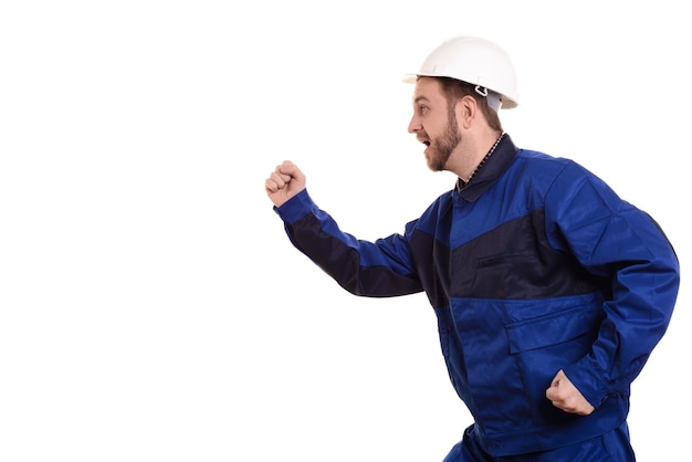 Man builder in hard hat and overalls runs for construction