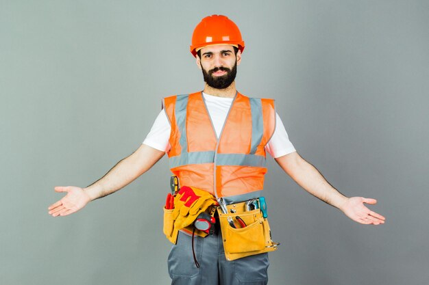 Man Builder with beard standing on gray background copy space