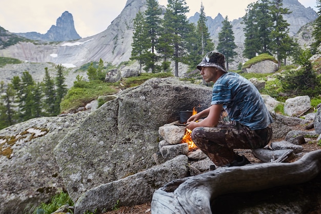 Man builds a campfire in the woods in nature