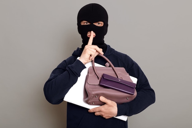 Photo man burglar holds laptop