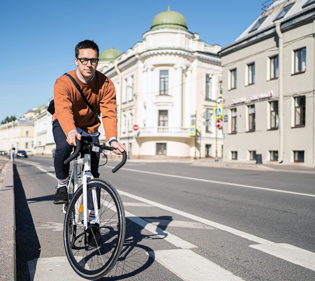 ビジネス自転車に乗った男が通勤する都市のエコトランスポート