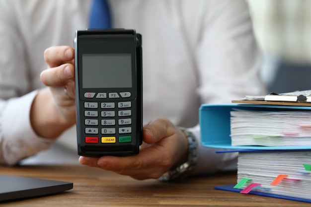 A man in business clothes shows wireless terminal