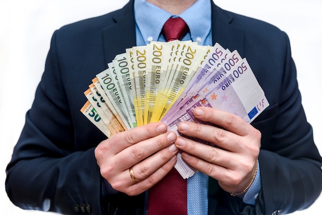 Man in business suit holds euro denominations