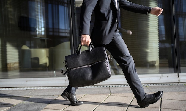 A man in a business suit is holding a briefcase in his hands