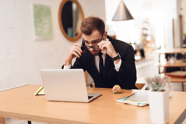 A man in a business suit is working in his office.