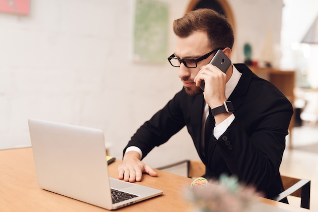 A man in a business suit is working in his office.