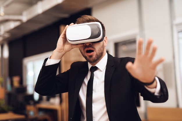 A man in a business suit looking into a virtual reality.