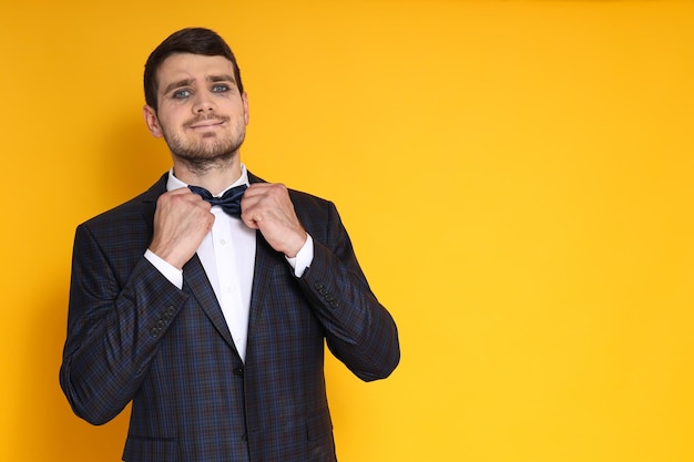 A man in a business suit with zombie makeup on a yellow background cheerful