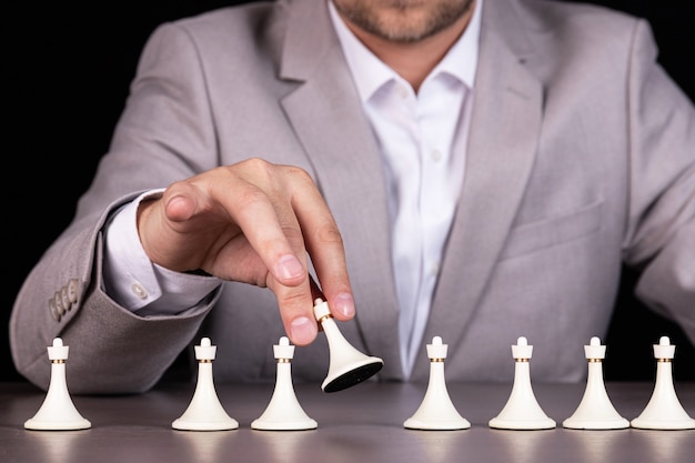 Man, businessman holds a white pawn