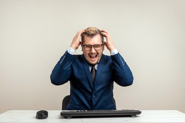 Photo man businessman is furious and angry at the computer