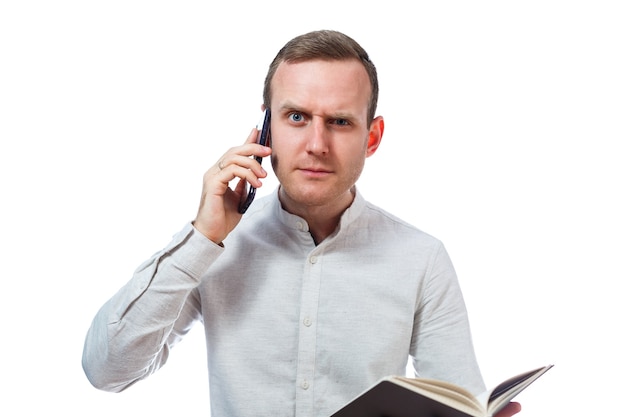 Man businessman, teacher, mentor examines entries in your diary and talking on a cell phone. Isolated on white background