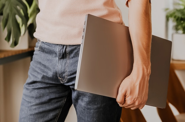 Man businessman with laptop in workspace in eco cafe with plants