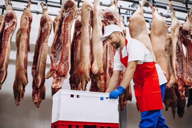 Foto macellaio uomo che spinge scatole al congelatore di carne