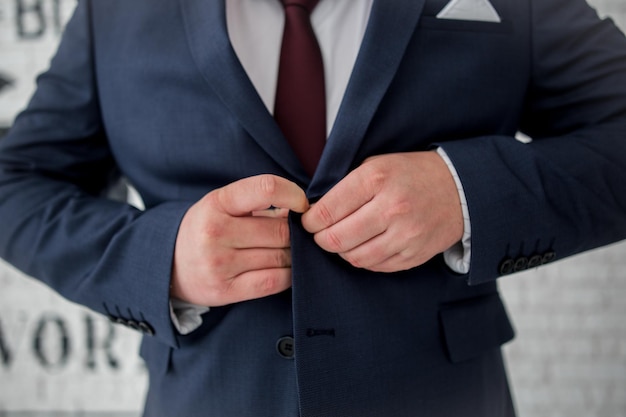 A man buttons a jacket from a suit