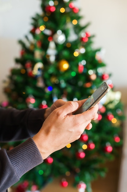 Man buying christmas new year gifts online using phone laptop