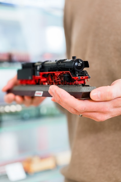 man buying model railroad in toy store