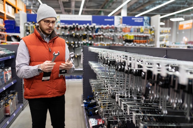 A man buys spanners in a hardware store