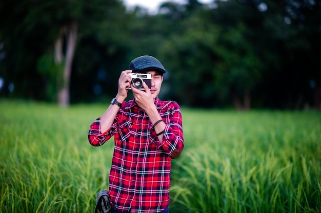 男とカメラは写真を撮って幸せそうに笑ってあなたのビジネスのための写真