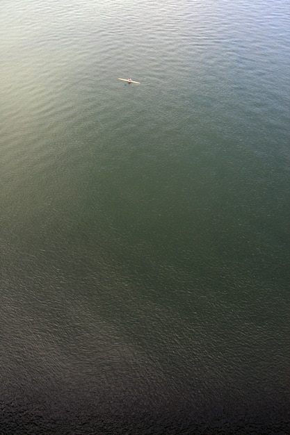 広大な海の上のカヌーの男